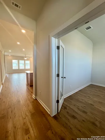 a view of an empty room and window and wooden floor