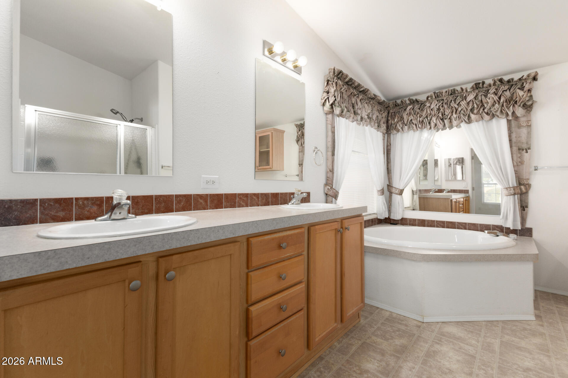 16101 North El Mirage Road, Unit 429 El Mirage, AZ 85335 - Photo 11 of 31 a bathroom with a double vanity sink a mirror and a bathtub