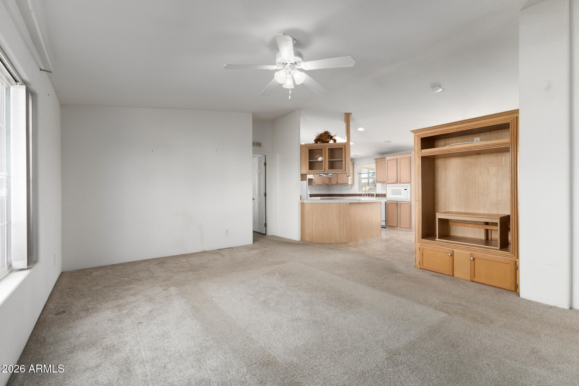 16101 North El Mirage Road, Unit 429 El Mirage, AZ 85335 - Photo 3 of 31 a view of a kitchen with wooden cabinet and a refrigerator