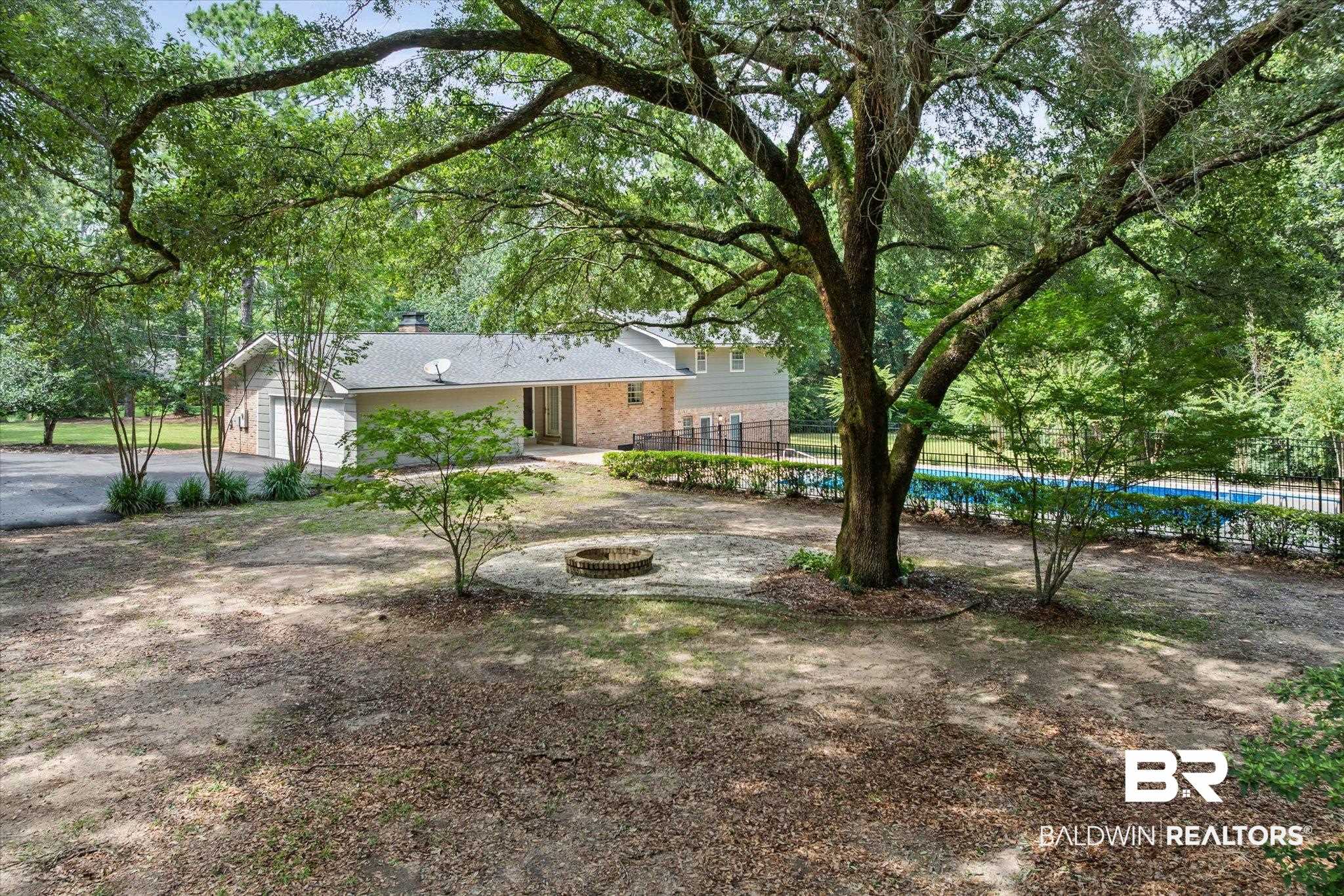 8301 Fordham Road Mobile, AL 36619 - Photo 51 of 57 Expansive yard featuring mature trees, a fire pit area, and a fenced swimming pool