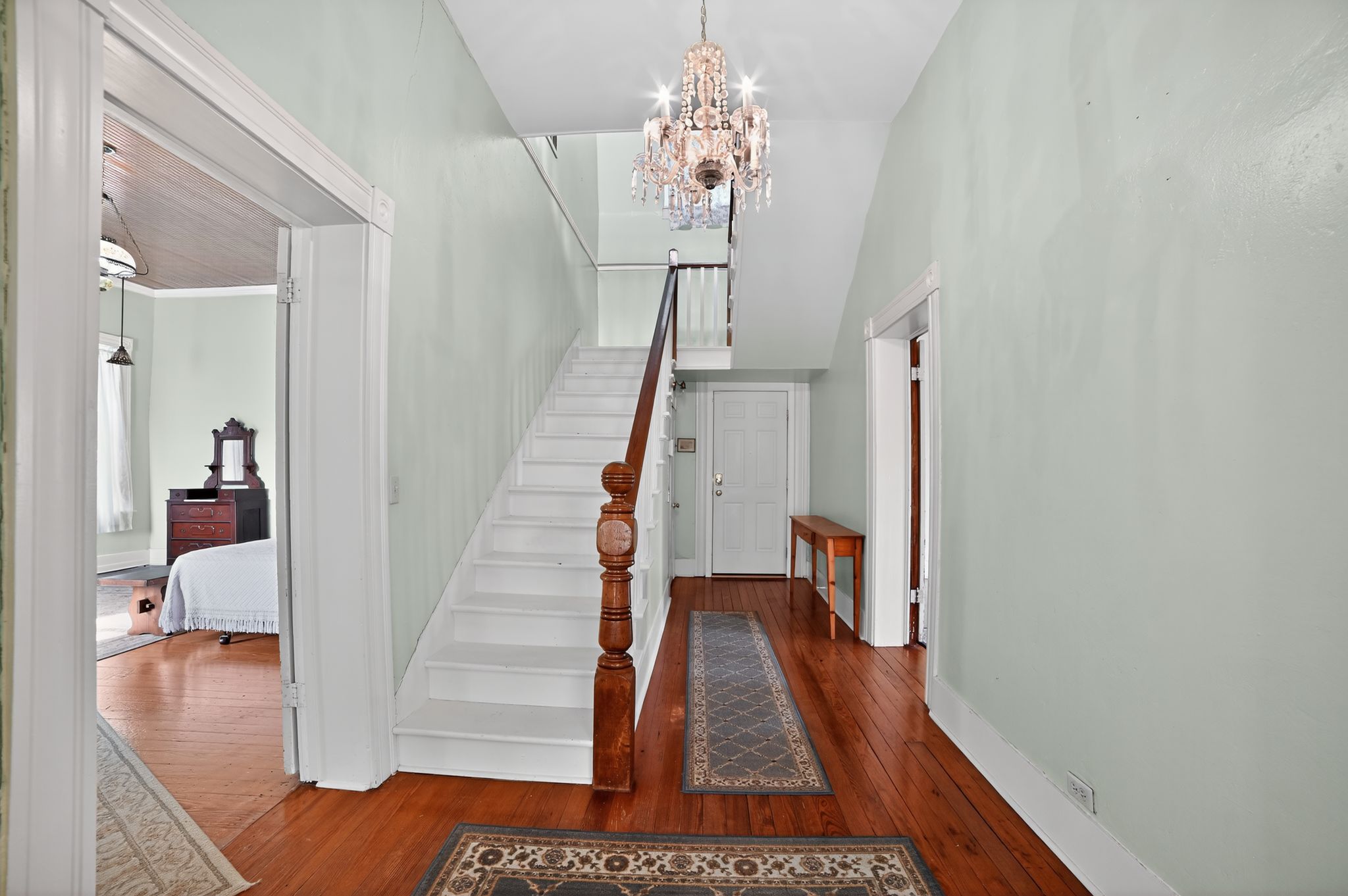 400 South Main Street Belton, TX 76513 - Photo 17 of 18 Stairs with hardwood / wood-style flooring and a chandelier