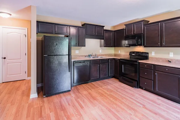 a kitchen with wooden floors stainless steel appliances and cabinets