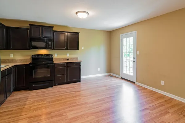 a kitchen with stainless steel appliances granite countertop a sink and cabinets with wooden floor