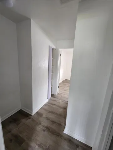 a view of a hallway with wooden floor and entryway