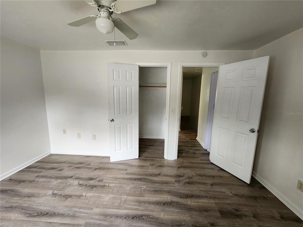 806 Southwest 64th Terrace, Unit C Gainesville, FL 32607 - Photo 27 of 28 an empty room with wooden floor and fan