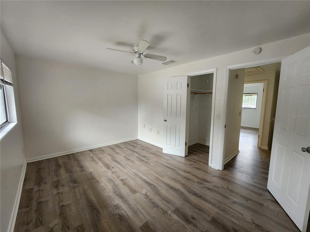 806 Southwest 64th Terrace, Unit C Gainesville, FL 32607 - Photo 28 of 28 an empty room with wooden floor closet and windows