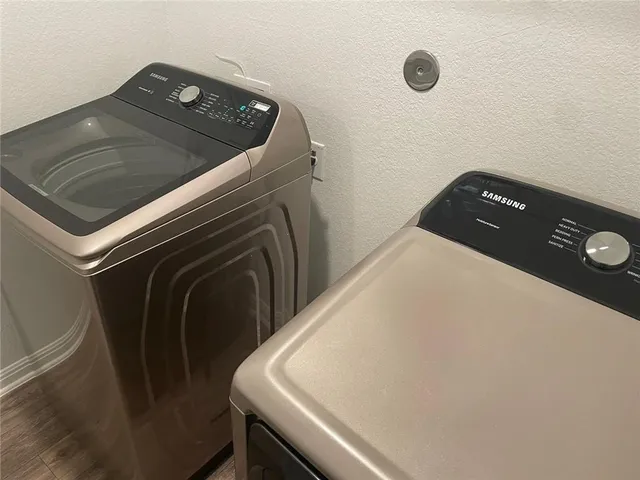 a utility room with wooden floor washer and dryer