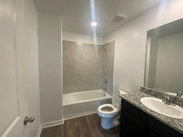 a bathroom with a granite countertop sink toilet and shower