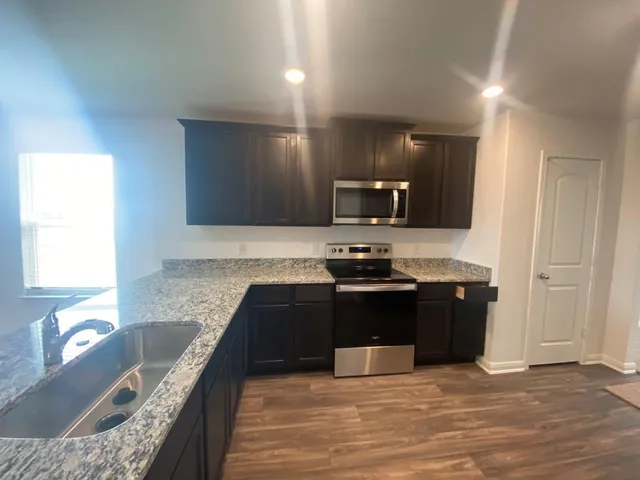 a kitchen with granite countertop stainless steel appliances and wooden cabinets