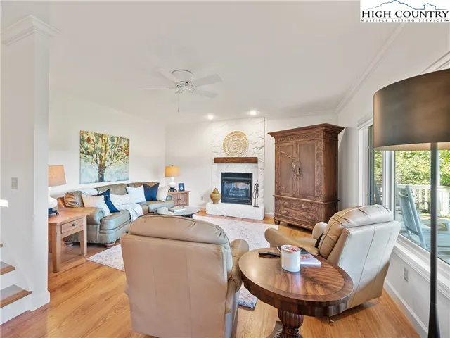 a living room with fireplace furniture and a large window