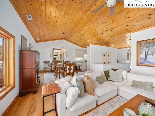 a living room with furniture a wooden floor and next to a window