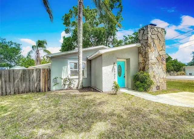 a view of a house with backyard and tree