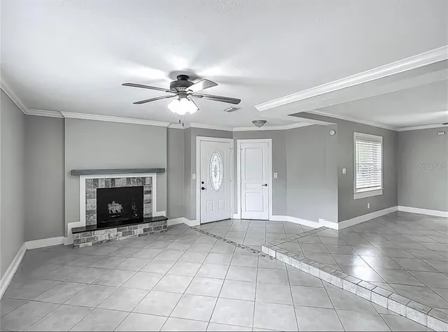 a view of an empty room with window and fireplace