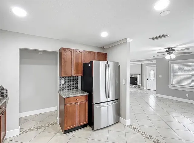 a kitchen with granite countertop a refrigerator and a stove top oven