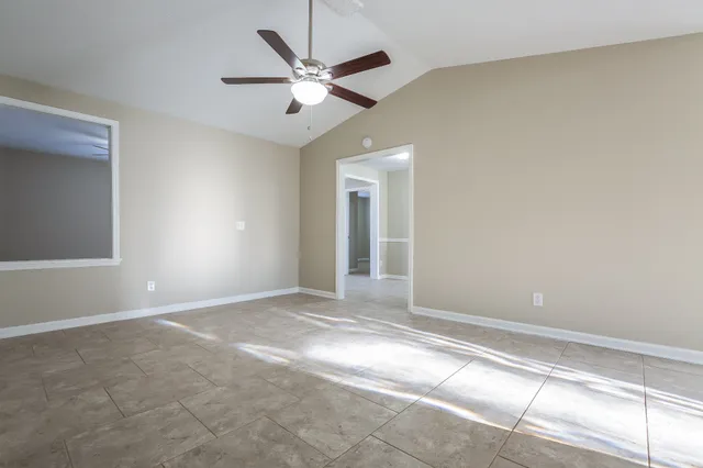 an empty room with fan and windows