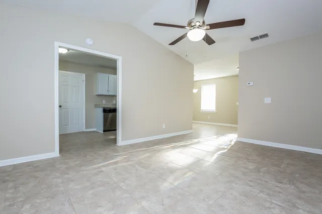 a view of an empty room and a ceiling fan window