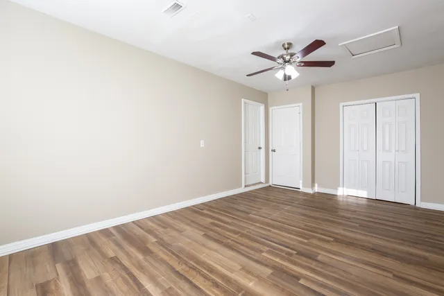 a view of an empty room with wooden floor