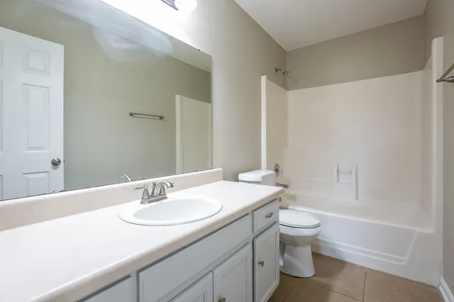 a bathroom with a granite countertop sink a toilet and a bathtub