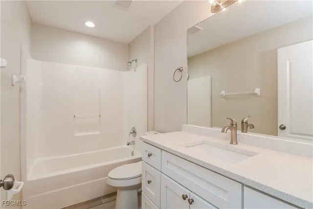 a bathroom with a sink a toilet and a large mirror