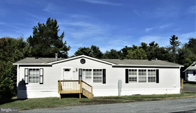 a view of a white house with a yard