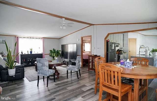 a dining room with furniture potted plants and wooden floor