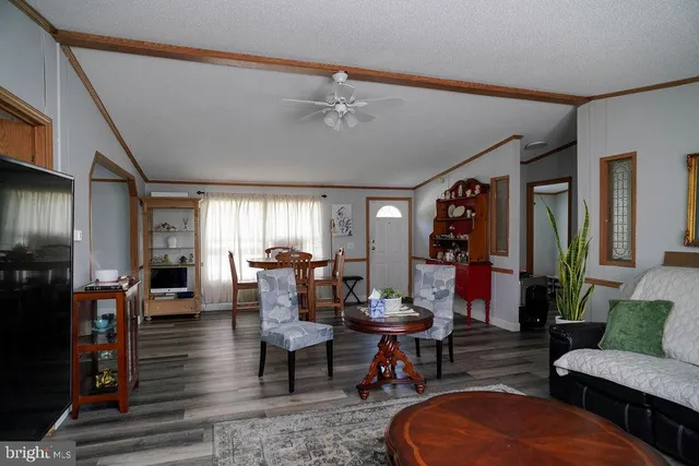 a living room with furniture a rug and a dining table