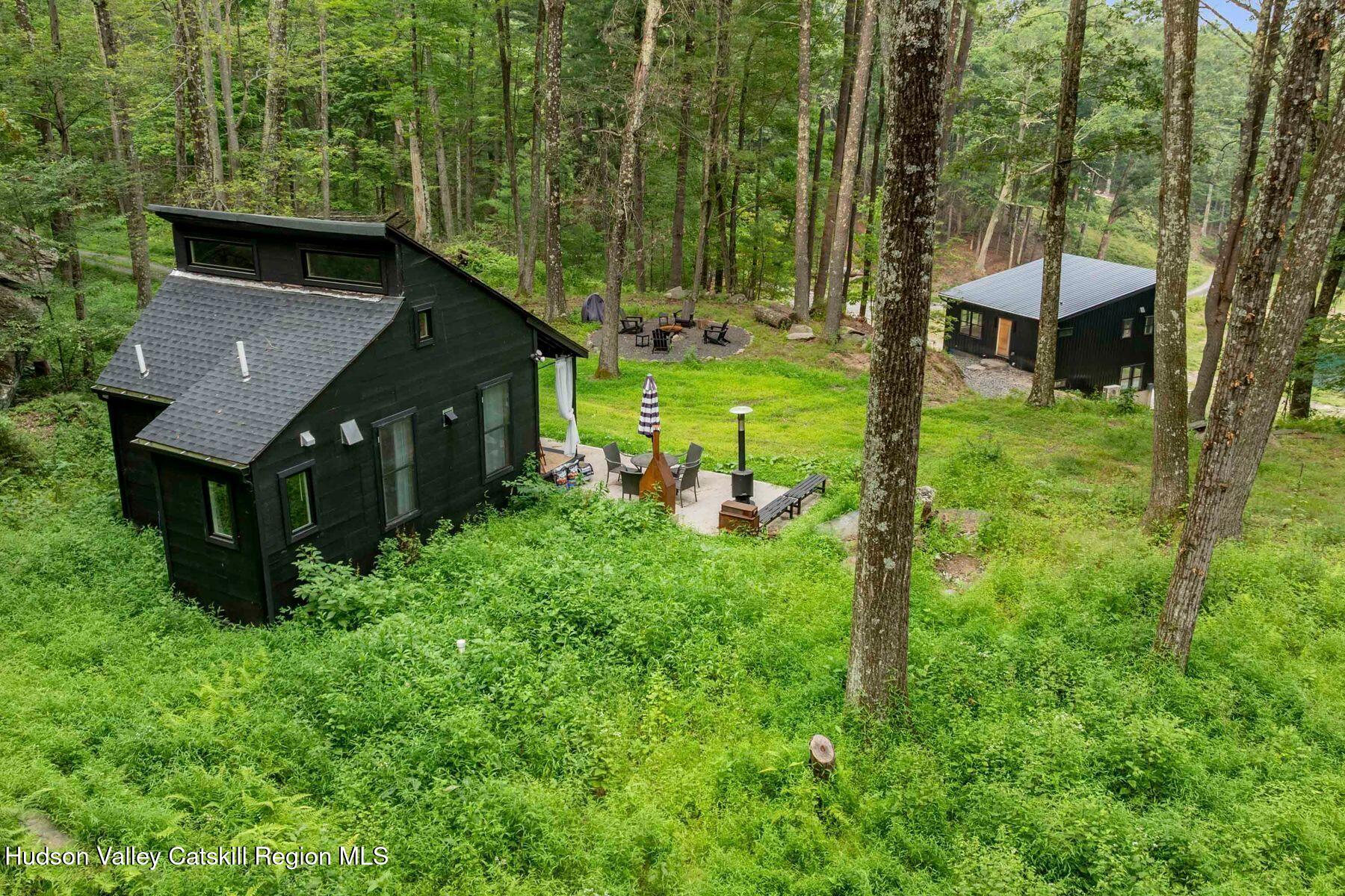 134 Irish Cape Road Napanoch, NY 12458 - Photo 2 of 47 a view of a backyard with table and chairs with wooden fence and trees