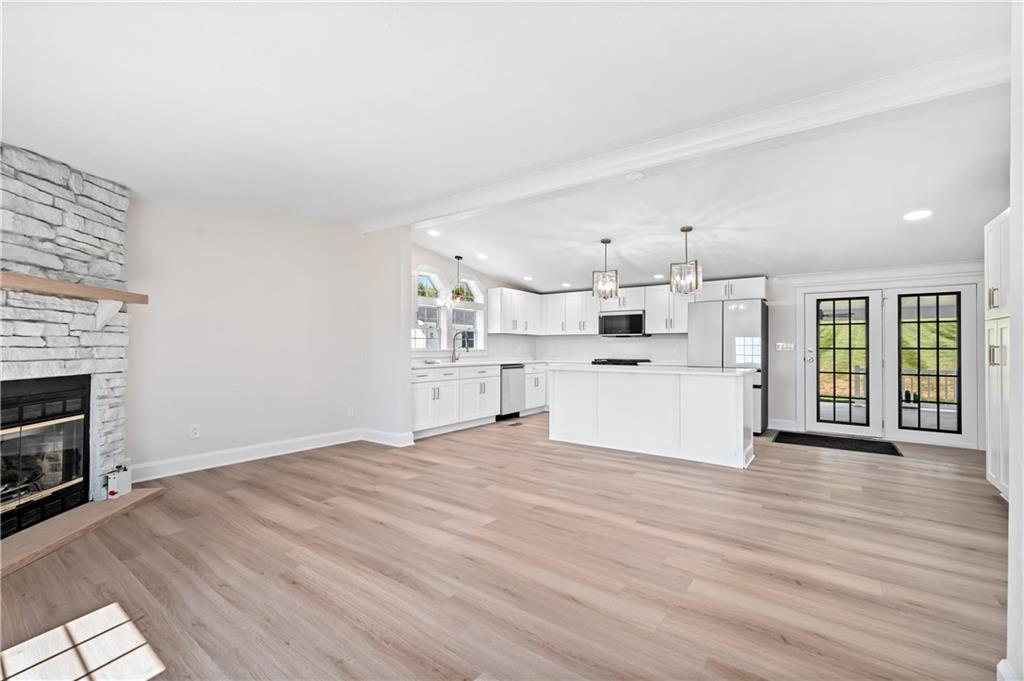 2118 Spooky Hollow Road Lower Burrell, PA 15068 - Photo 11 of 44 a view of a kitchen with wooden floor and a fireplace