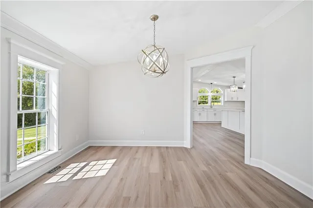 a view of empty room with wooden floor and windows