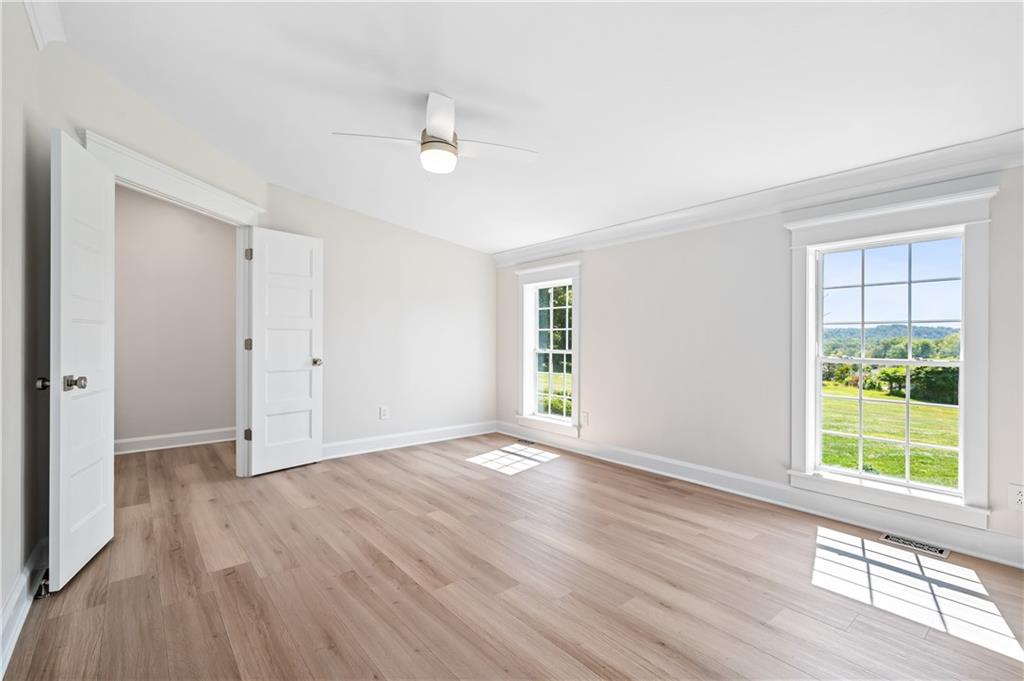 2118 Spooky Hollow Road Lower Burrell, PA 15068 - Photo 18 of 44 a view of an empty room with wooden floor and a window