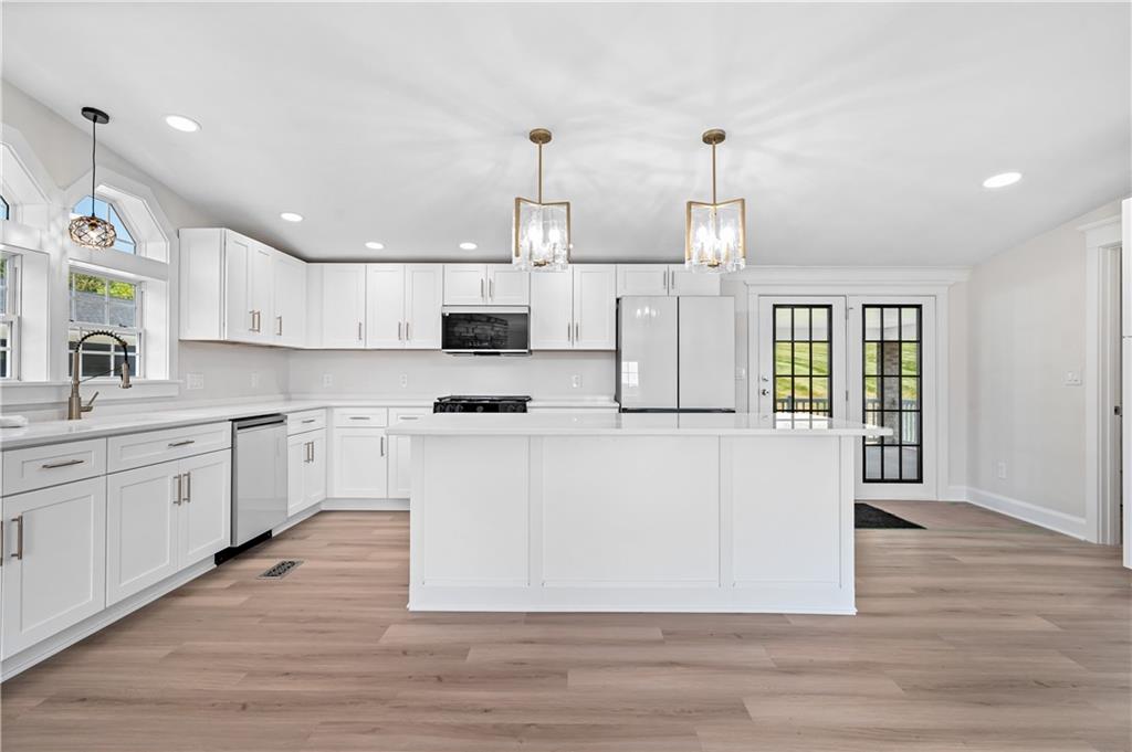 2118 Spooky Hollow Road Lower Burrell, PA 15068 - Photo 5 of 44 a large kitchen with granite countertop a stove top oven a sink a counter space and cabinets