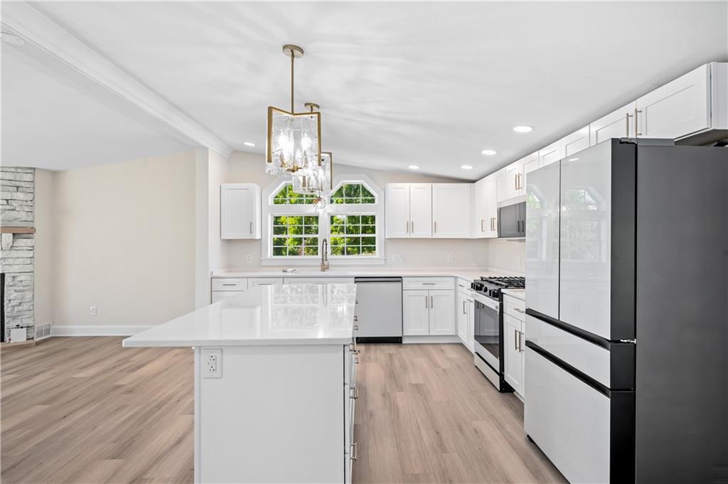 2118 Spooky Hollow Road Lower Burrell, PA 15068 - Photo 6 of 44 a kitchen with stainless steel appliances a refrigerator a stove a sink and a wooden floors