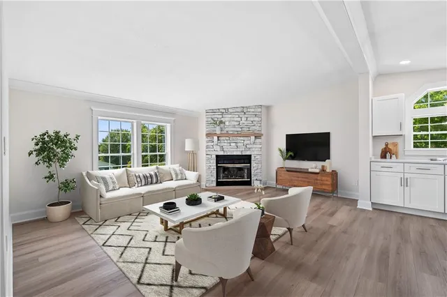 a living room with furniture a flat screen tv and a fireplace