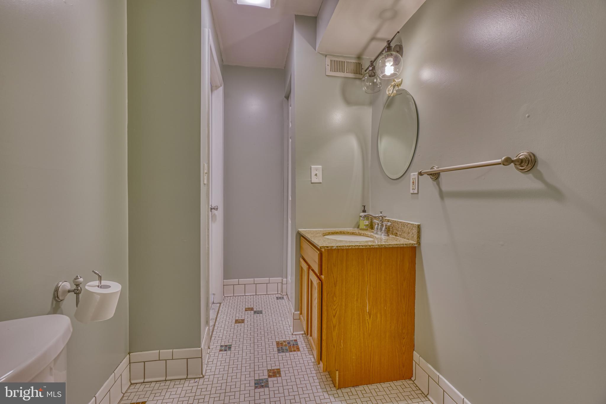 644 Jasper Street Baltimore, MD 21201 - Photo 18 of 27 a bathroom with a sink a mirror a toilet and vanity