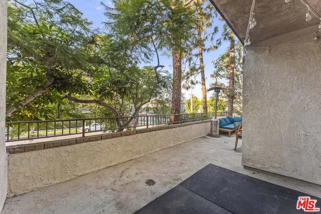 a porch with a bench and trees