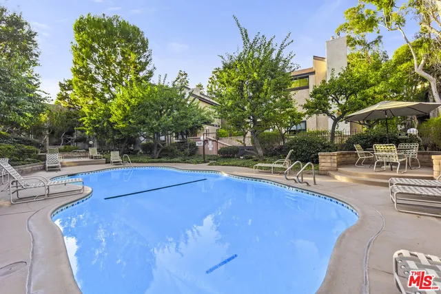 a view of a swimming pool with outdoor seating and plants