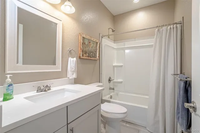 a bedroom with a bed and a flat tv screen on dresser