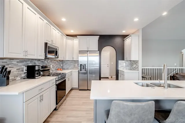 a kitchen with a sink stainless steel appliances a window and a counter top space
