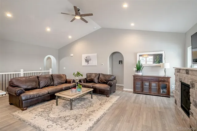 a living room with furniture a fireplace and a kitchen view