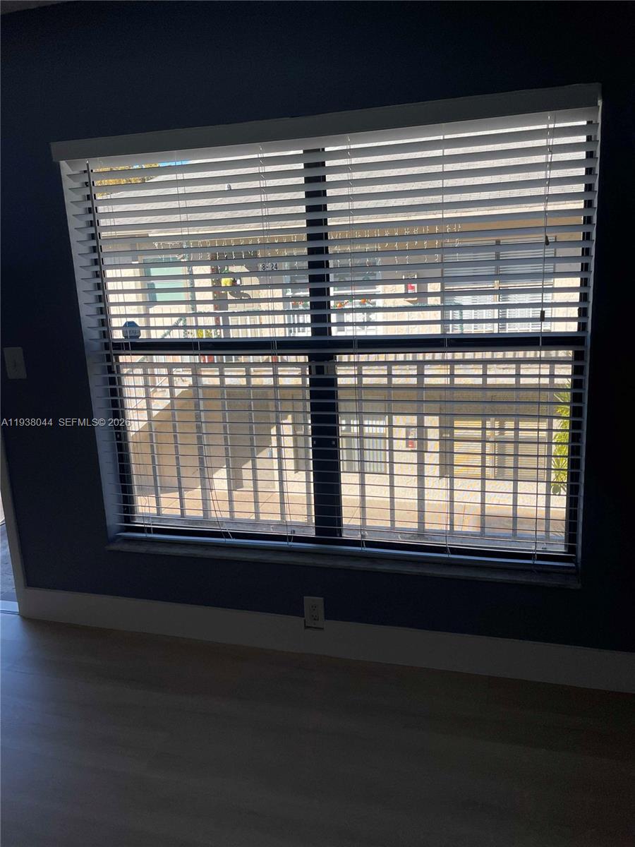 15330 Southwest 72nd Street, Unit 721 Miami, FL 33193 - Photo 12 of 15 a view of an empty room with wooden floor and a window