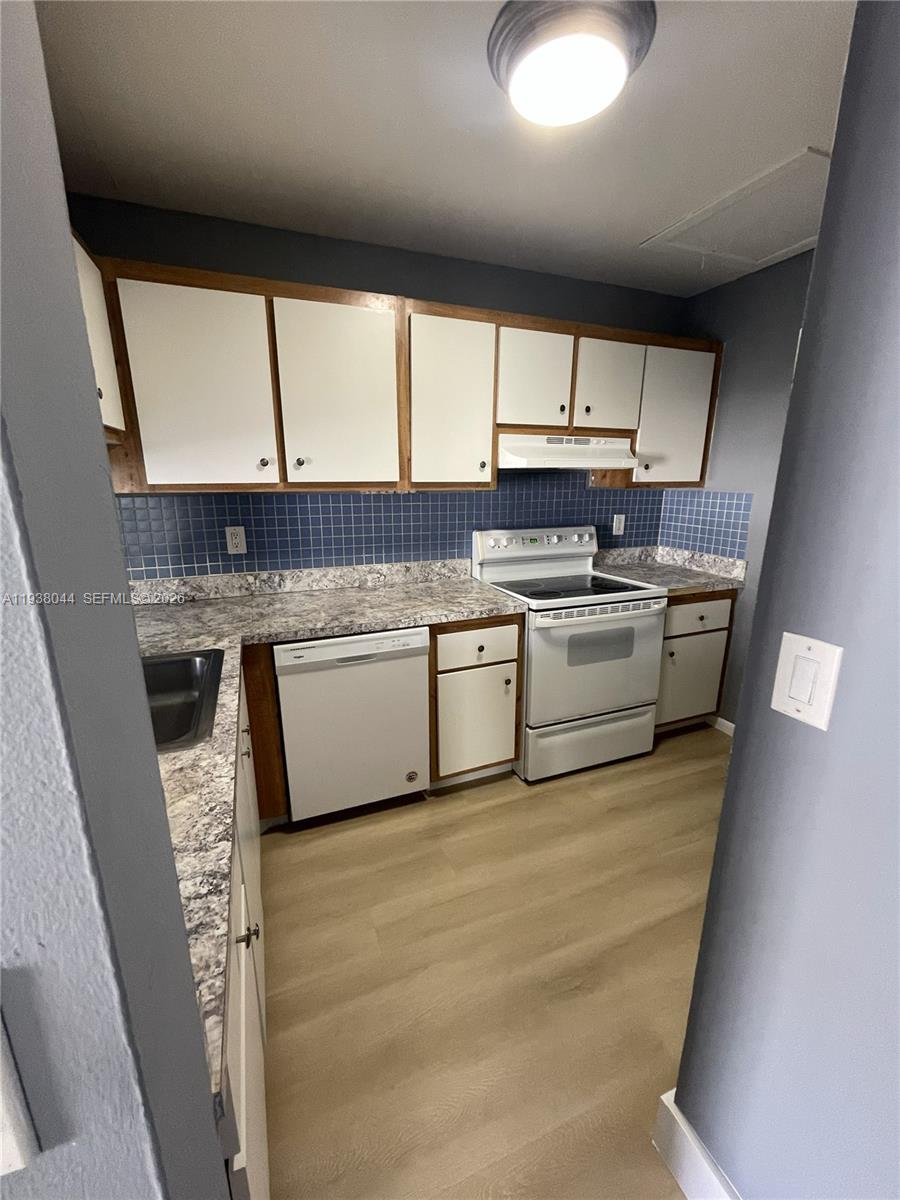 15330 Southwest 72nd Street, Unit 721 Miami, FL 33193 - Photo 5 of 14 a kitchen with stainless steel appliances granite countertop a sink a stove and a refrigerator
