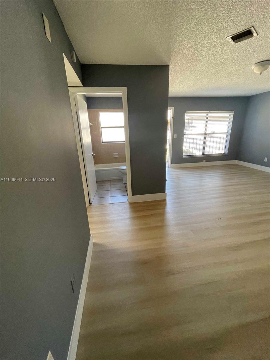 15330 Southwest 72nd Street, Unit 721 Miami, FL 33193 - Photo 9 of 15 a view of hallway with window and wooden floor