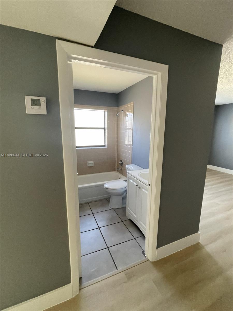 15330 Southwest 72nd Street, Unit 721 Miami, FL 33193 - Photo 10 of 14 a bathroom with a toilet sink and a mirror