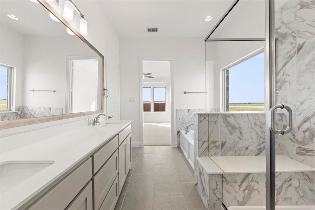 3306 Agnew Street Celina, TX 75009 - Photo 18 of 27 a bathroom with a granite countertop sink a bathtub and mirror