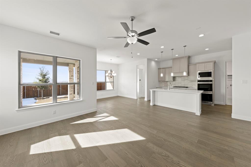 3306 Agnew Street Celina, TX 75009 - Photo 5 of 27 a view of kitchen with kitchen island wooden floor and stainless steel appliances