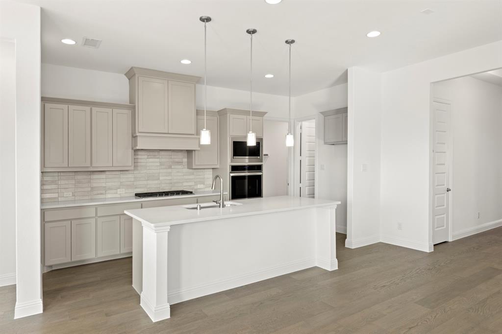 3306 Agnew Street Celina, TX 75009 - Photo 8 of 27 a large kitchen with cabinets and stainless steel appliances