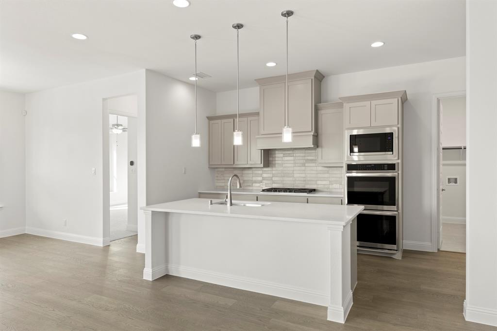 3306 Agnew Street Celina, TX 75009 - Photo 9 of 27 a kitchen with kitchen island a sink stainless steel appliances and cabinets