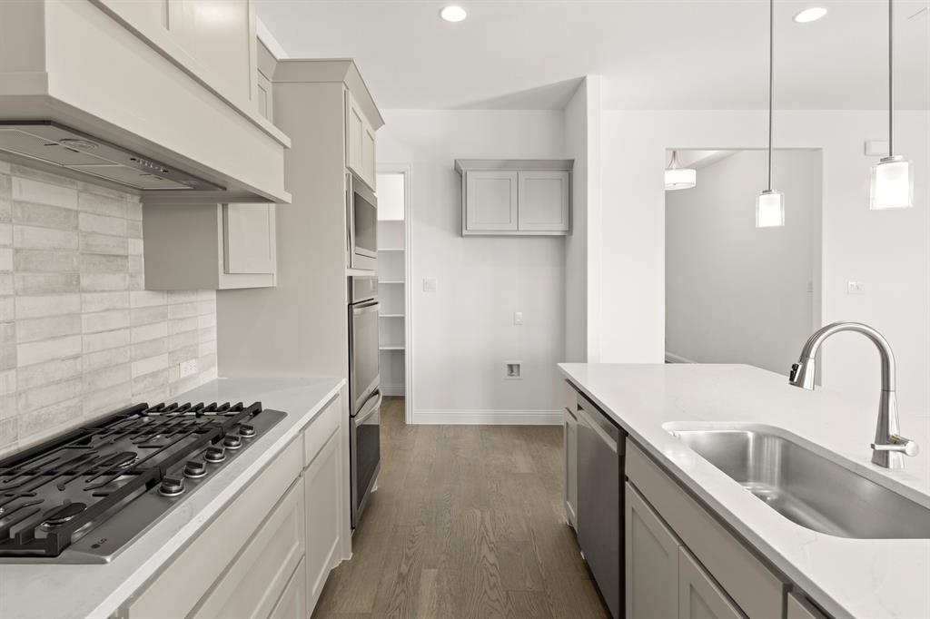 3306 Agnew Street Celina, TX 75009 - Photo 10 of 27 a kitchen with kitchen island a sink stove and refrigerator