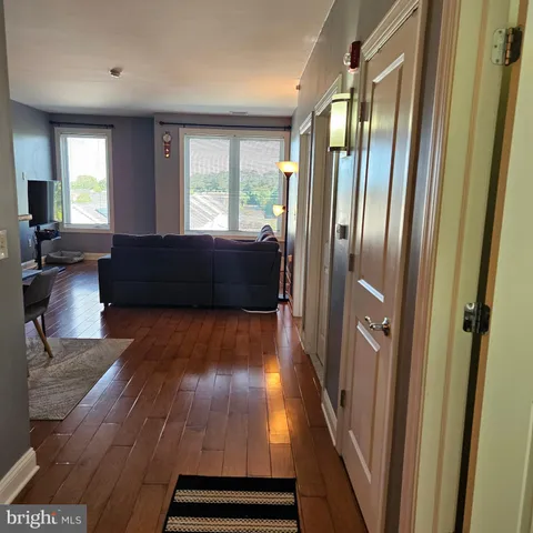 a living room with wooden floor and a large window