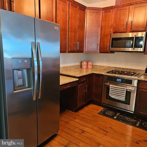 a kitchen with stainless steel appliances granite countertop a stove a sink and a microwave